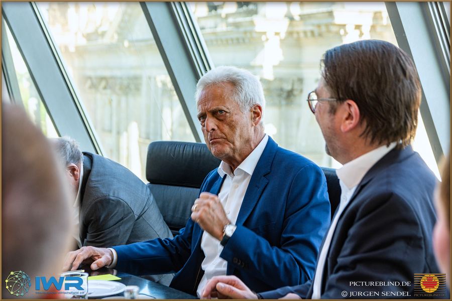 Zwei Gesprächspartner im Profil, einander zugewandt, im Hintergrund die Fassade des Reichstagsgebäudes.